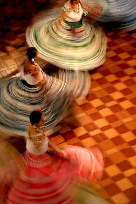 Bailarinas girando con sus faldas en movimiento sobre un piso de azulejos
